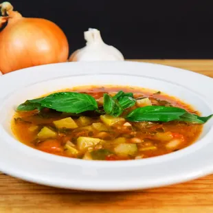 a bowl of vegetable soup on a wooden table