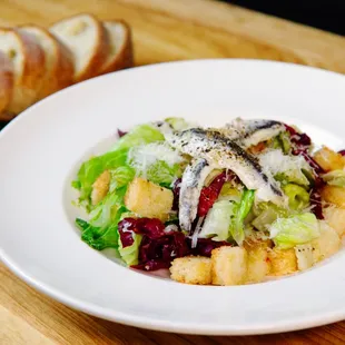 a white plate with a salad and bread