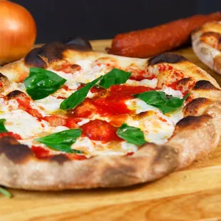 two pizzas on a cutting board