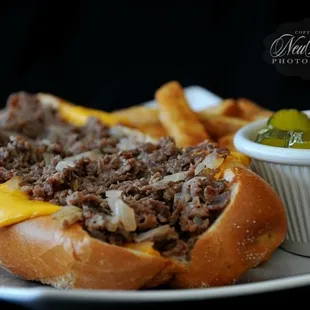 Cheesesteak Sub with a side of pickles.
