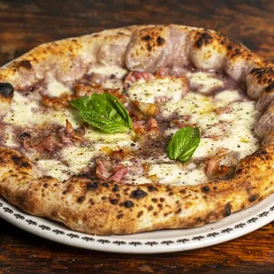 a pizza on a plate on a wooden table