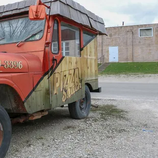 an old, rusted truck parked on the side of the road
