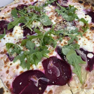 a beet and spinach pizza in a box