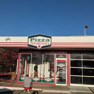 a man standing in front of a pizza station