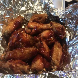 a plate of chicken wings covered in bbq sauce