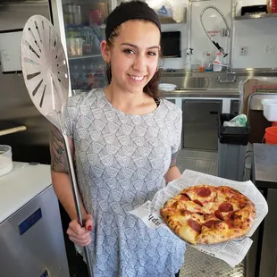 a woman holding a pizza