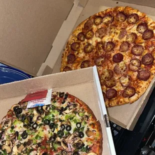 two pizzas in open boxes
