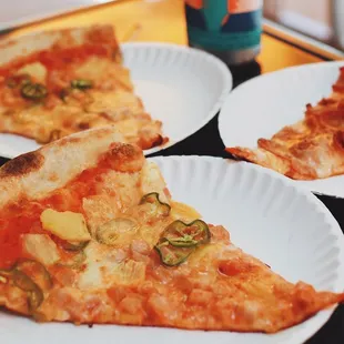 three slices of pizza on paper plates