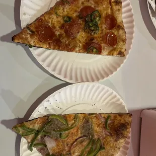 two slices of pizza on paper plates