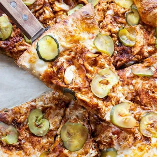 Nashville Hot Honey Chicken Pizza, topped with pickles! Available gluten free, dairy free, and vegan.