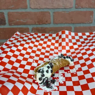 a croissant on a red and white checkered paper