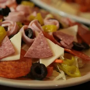 a plate of pepperoni, olives, and cheese