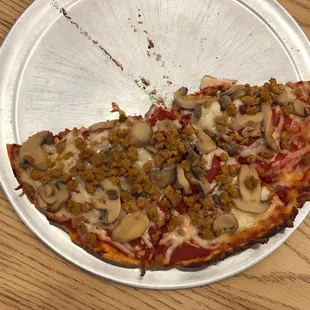 a half eaten pizza on a paper plate