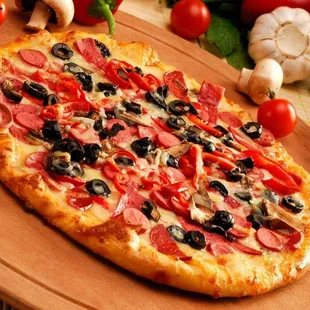 a pizza with pepperoni, olives, and tomatoes