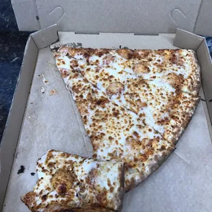 One slice of Cheese pizza with a almost fully eaten slice by its side