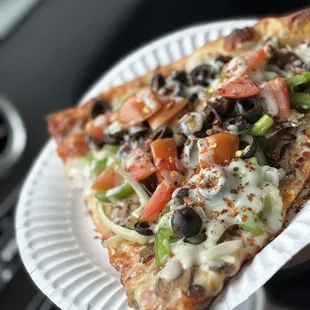 a slice of pizza on a paper plate