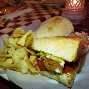 Chicken Parm sub with cheese and pepperoncinis and a side of chips and Italian coleslaw.