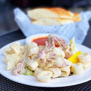a plate of food with a sandwich in the background
