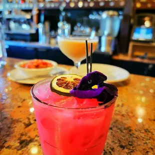 a pink cocktail with a purple garnish garnish garnish garnish garnish garn