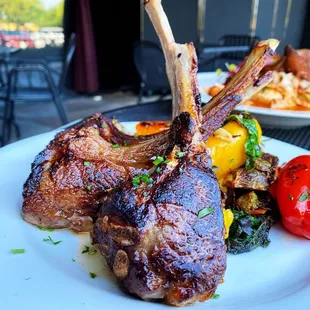 lamb chops and vegetables on a white plate