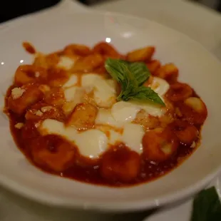 a bowl of pasta with cheese and basil
