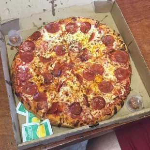 a person holding a box of pepperoni pizza