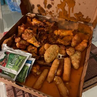 Wings, mozzarella sticks, jalapeño poppers all covered in wing sauce!
