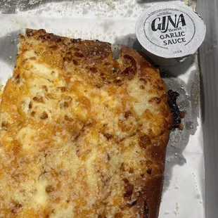 a slice of cheese pizza in a box
