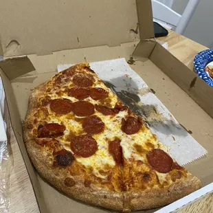 a slice of pepperoni pizza in a box