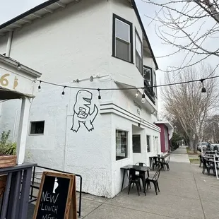 Outside - white building. Some outside seating as well.