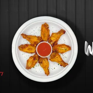 a plate of fried wings with ketchup