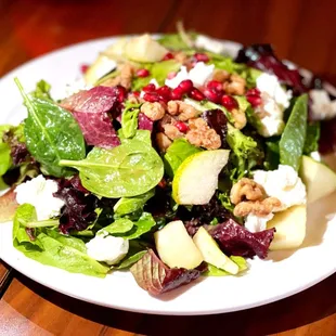 a plate of salad on a wooden table