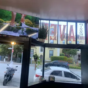 Me looking out of the restaurant with tables inside and a TV