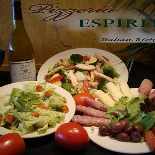 two plates of food and a bottle of wine