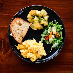 Scrambled eggs with potatoes, home-made bread and salad.