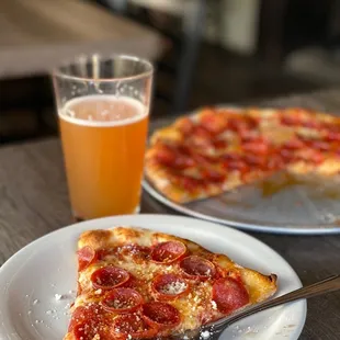 a slice of pizza and a glass of beer