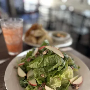 a plate of salad with apples and cranberries