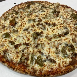 a cheese pizza with sausage and peppers