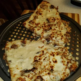 2 personal white cheese pizza pies with mushrooms reheated at home