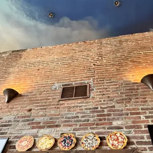 pizzas on a brick wall