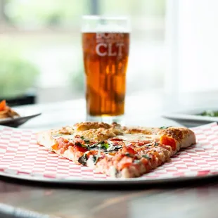 a slice of pizza and a glass of beer