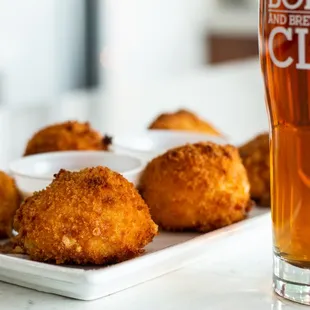 a glass of beer and a plate of fried chicken nuggies