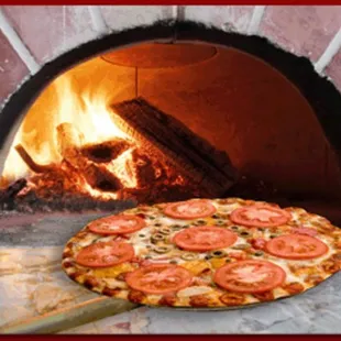 a pizza in front of a brick oven