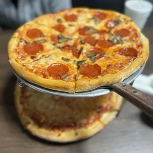 Top is 4 cheese with pepperoni and mushroom. Bottom is regular cheese with half pineapple.