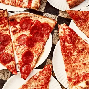 slices of pepperoni pizza on paper plates