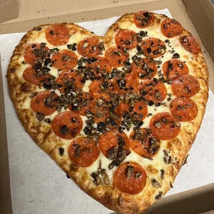 a heart shaped pizza in a box