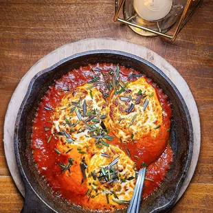 a skillet filled with tomato sauce and cheese