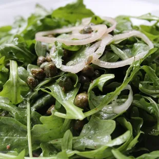 a plate of salad with onions and spinach