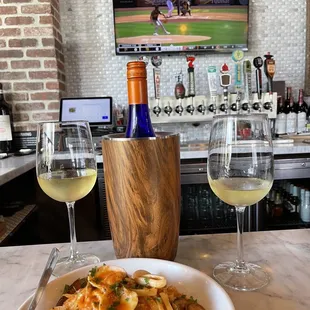 a bowl of pasta and two glasses of wine