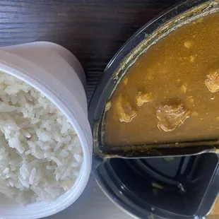 a bowl of rice and a container of curry